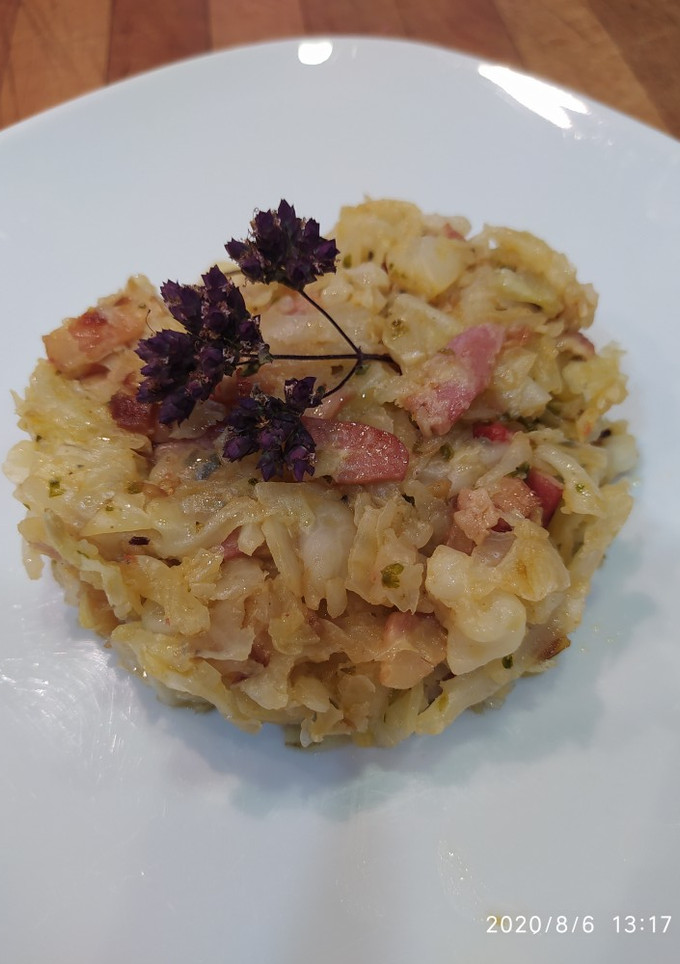 Una foto de Col salteada con bacon, escalonia, ajo, tomate cherry y orégano