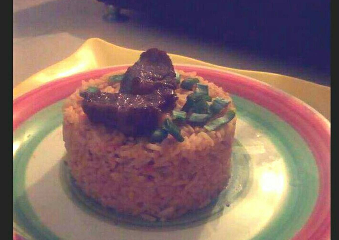 Jollof rice garnished with Beef and spring onions