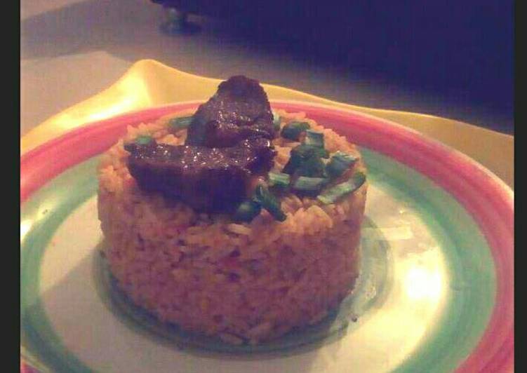 Jollof rice garnished with Beef and spring onions