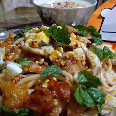 A picture of Khowsey with white curry.