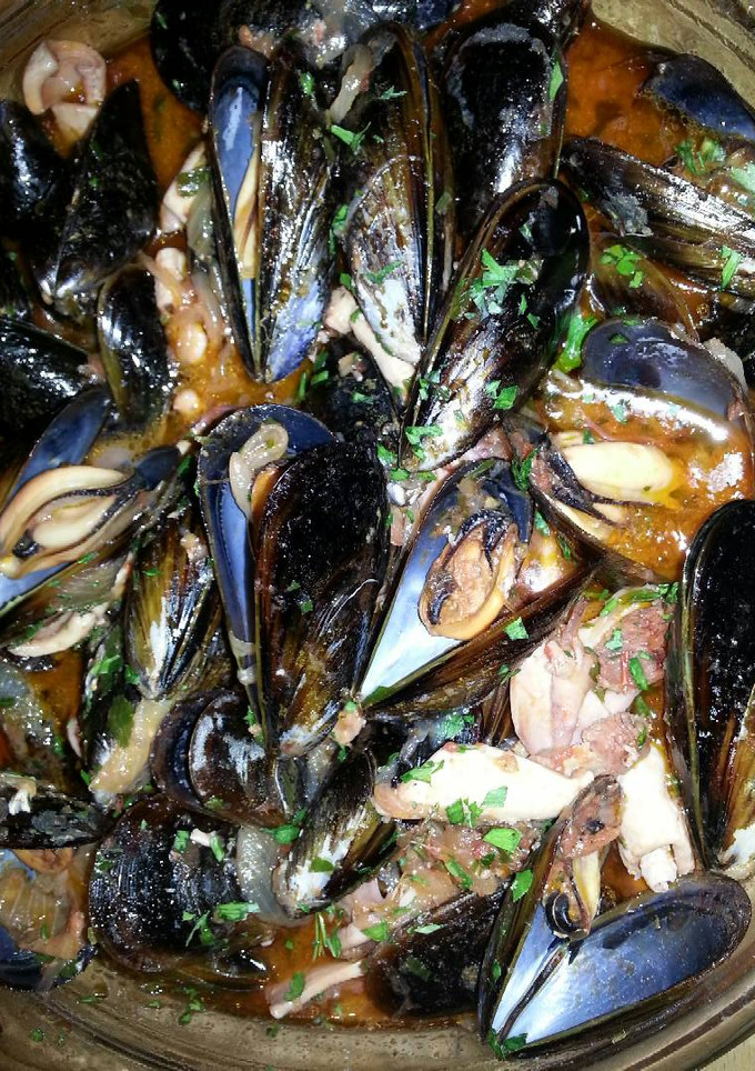 Una foto de Mejillones y calamares con salsa de tomate