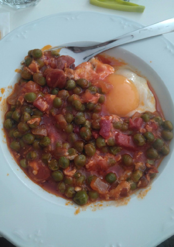 Una foto de Guisantes con tomate frito, jamón, chorizo y huevo