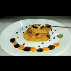A picture of Eggless Pancakes With Mango and Chocolate Sauce.