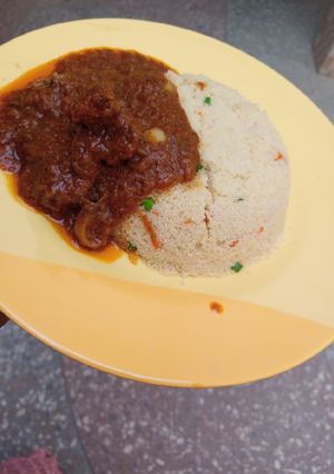 A picture of Garnished couscous with beef stew.