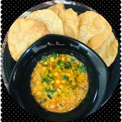 A picture of Dhaba style chana masala with puri.