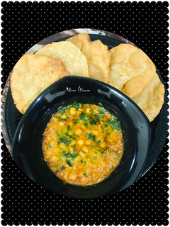A picture of Dhaba style chana masala with puri.