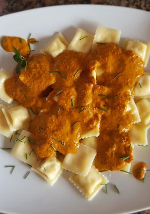 Una foto de Ravioles de ricota, con salsa de zanahoria y morrón