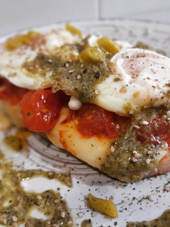 Una foto de Tosta de huevo frito, tomate cherry con pesto y queso fundido