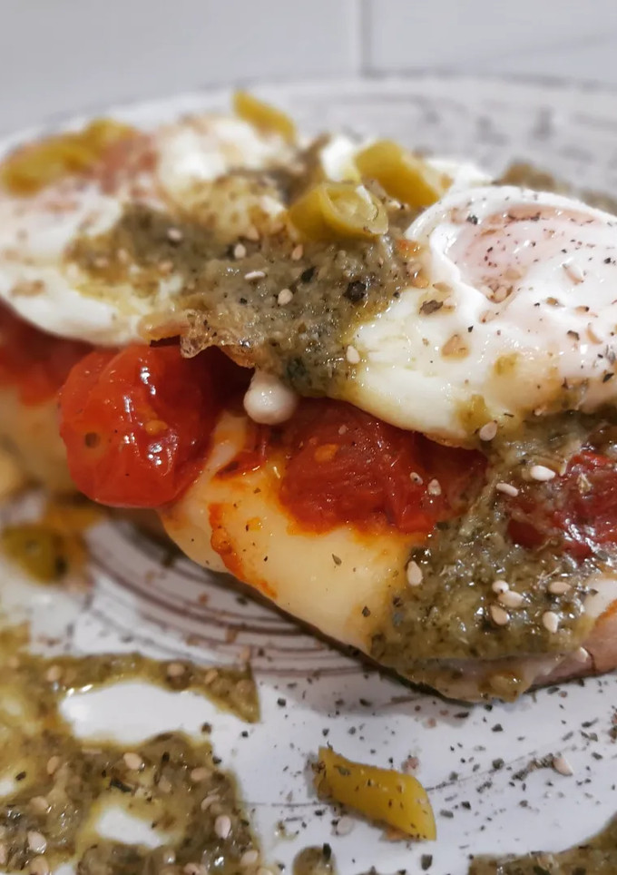 Una foto de Tosta de huevo frito, tomate cherry con pesto y queso fundido