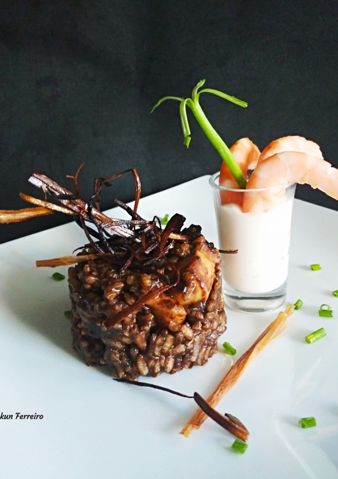 Una foto de Arroz negro, crujiente de puerro y langostinos alioli