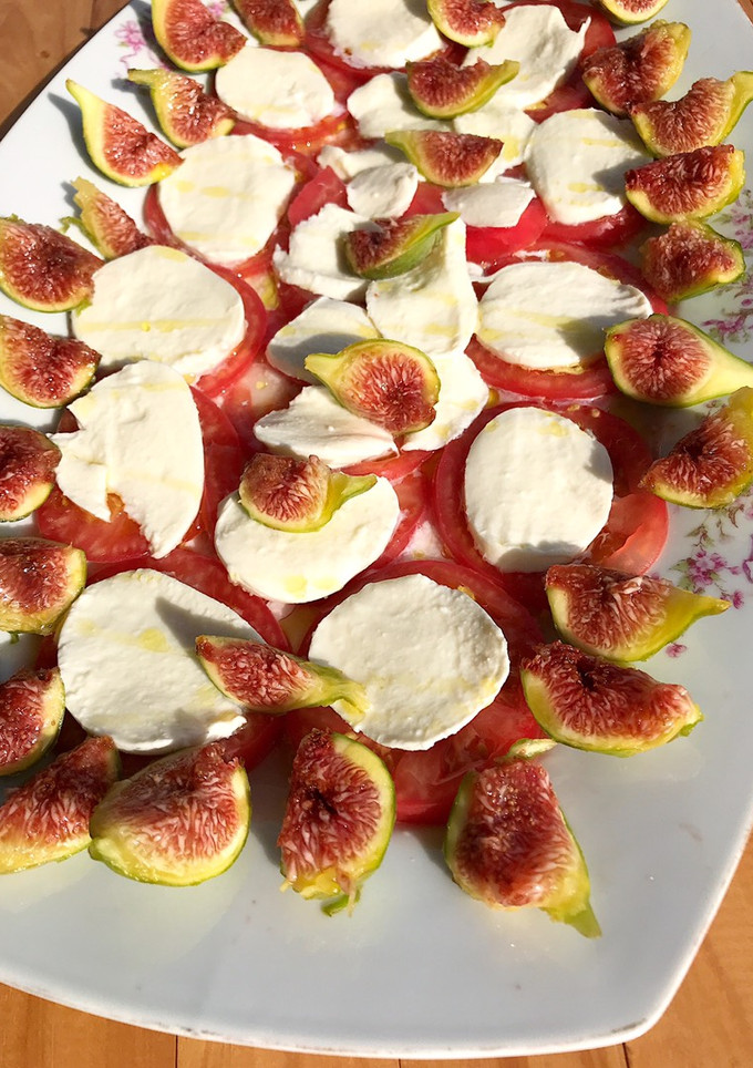 Una foto de Carpaccio de tomate y mozzarella con higos