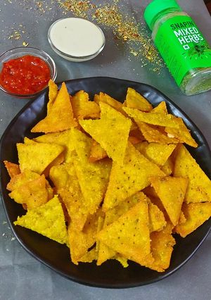 A picture of Nachos with cheesy dip.