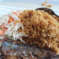 A picture of Jollof rice coslaw with fried fish.