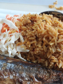 A picture of Jollof rice coslaw with fried fish.