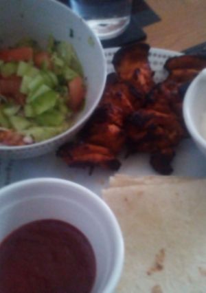 A picture of Grilled Chicken Kebabs, salad and wraps with dips.