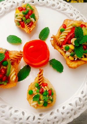 A picture of Crispy Edible Diyas filled with Pasta Chat.