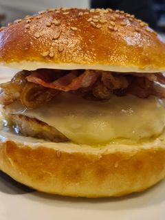 Una foto de Hamburguesa de pollo al curry, cebolla caramelizada, queso-bacon