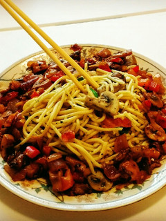 A picture of Italian Spaghetti with pan fried mushrooms.
