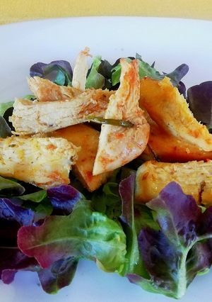 A picture of Baked Chicken Breast Strips Served on a Bed of Salad.