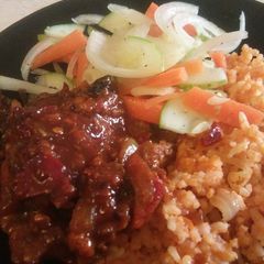 A picture of Tomato rice with chicken and salad.