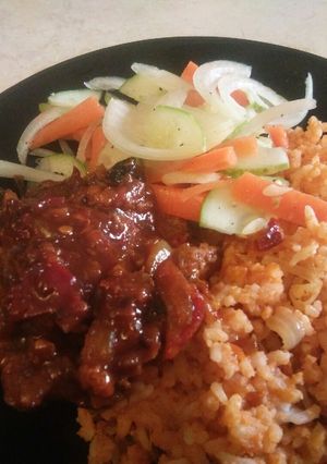 A picture of Tomato rice with chicken and salad.