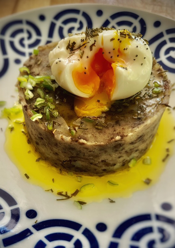 Una foto de Patatas enmascaradas con morcilla y huevo poché