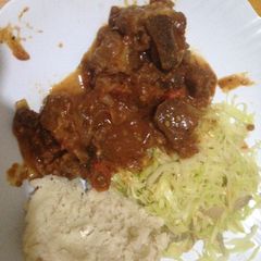 A picture of Ugali wa Mala served with fried beef and cabbage.