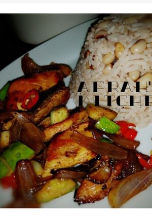 A picture of Rice and beans with chicken sauce.