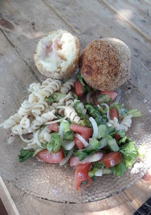 Una foto de Bombas de papas con jamón y queso con ensalada y fideos