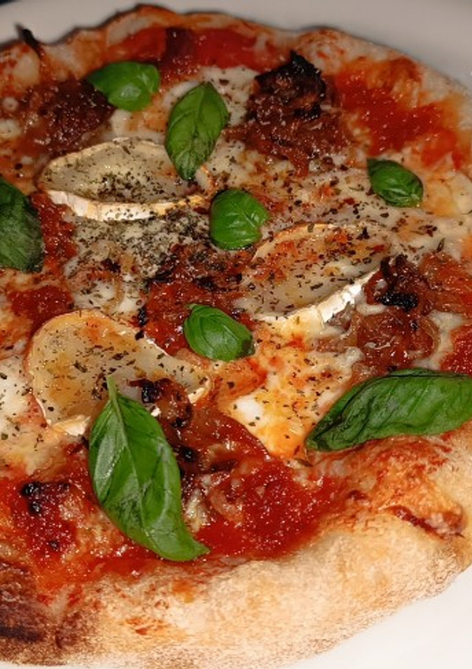 Una foto de Pizza de sobrasada y cebolla caramelizada