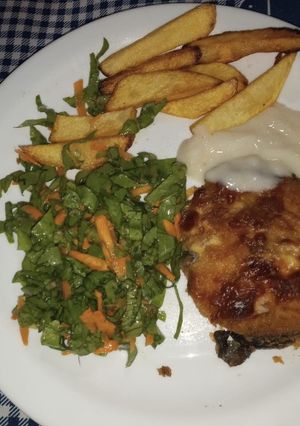 Una foto de Milanesas de surubí gratinada con salsa blanca papas y ensalada