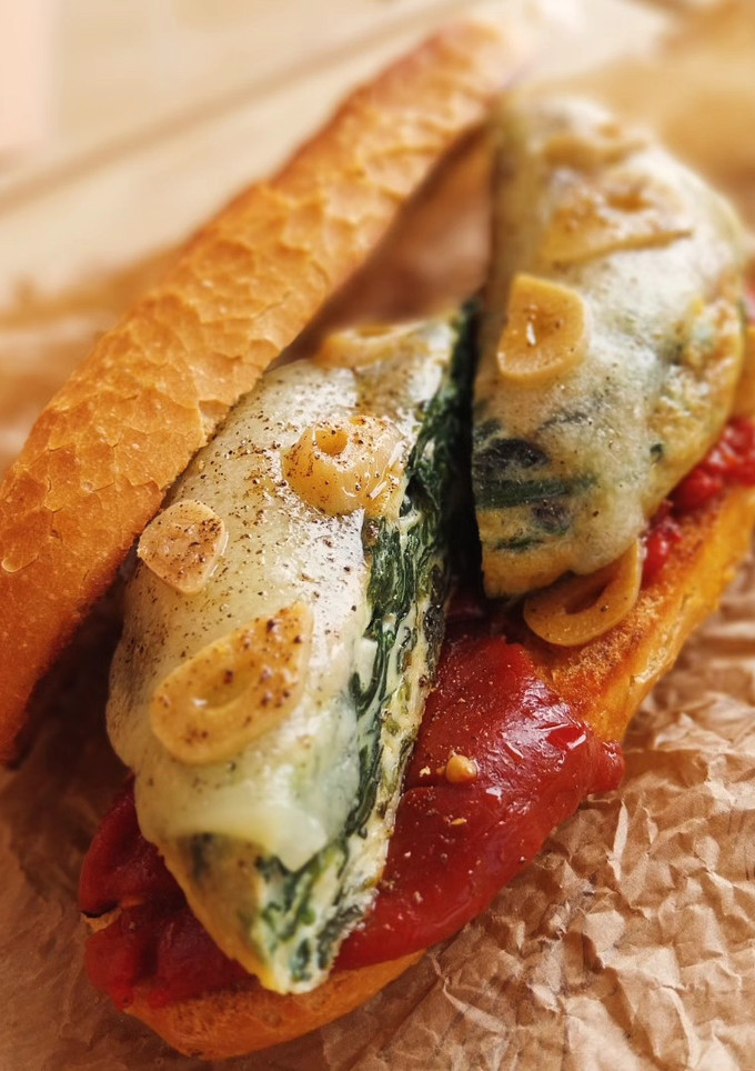 Una foto de Bocadillo de tortilla de espinacas con Idiazábal y piquillos confitados