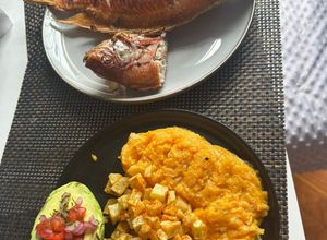 Una foto de Mojarra al Barril con Cremoso de Auyama, Papa Crispy y Aguacate Relleno