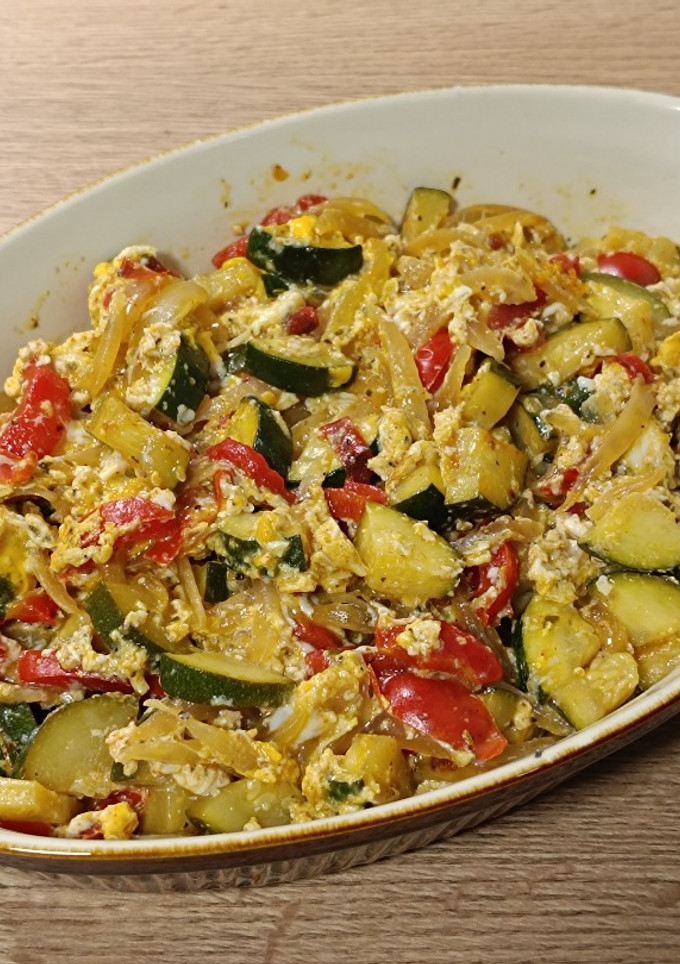 Una foto de Huevos rotos con calabacín y pimiento