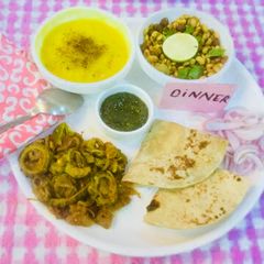 A picture of Yellow Moong Dal,Karela,Onions Bhaji,Whole lentils salad,mint chutney,Chapatis.
