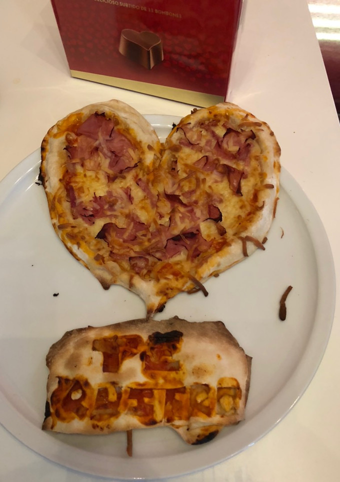 Una foto de Pizza de jamón y bacon con el borde relleno de queso de cabra con forma de corazón y tarjeta de masa