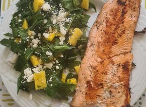 Una foto de Trucha al ajillo con ensalada de espinaca y mango 🐟🥭🌿