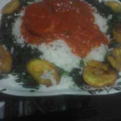 A picture of White rice and stew with steamed spinach.