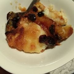 A picture of Bread and butter pudding with jam and cranberries.