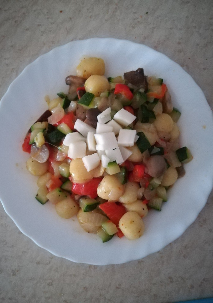 Una foto de Ñoquis con queso, setas y verduras