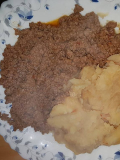 A picture of Mashed Potatoes served with minced meat.