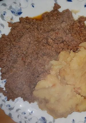 A picture of Mashed Potatoes served with minced meat.