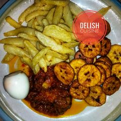 A picture of Fried Irish potato/plantain and boiled egg with pepper sauce.