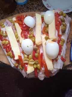 Una foto de Colita rellena con panceta, queso, morrón, aceitunas y huevo