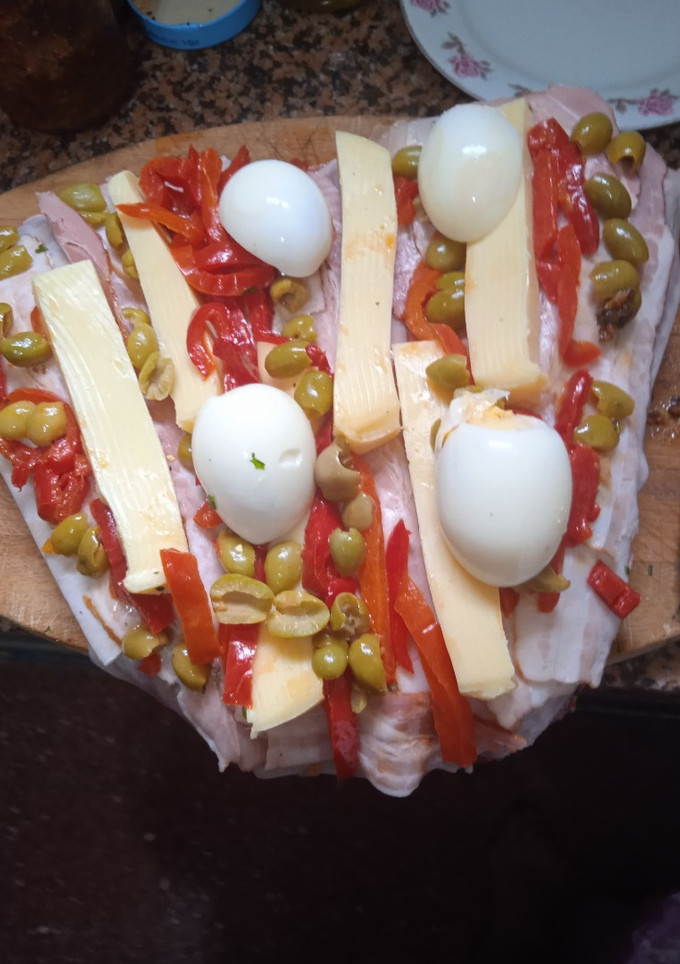 Una foto de Colita rellena con panceta, queso, morrón, aceitunas y huevo
