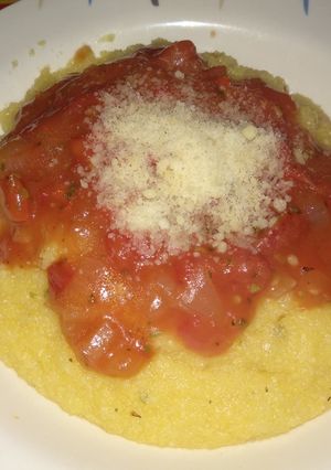 Una foto de Polenta con queso y salsa