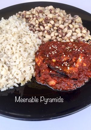 A picture of Rice and beans with hot sauce.
