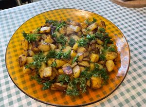 Une photo de Pommes de terre sautées aux pickles, ail noir et persil