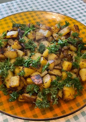 Une photo de Pommes de terre sautées aux pickles, ail noir et persil