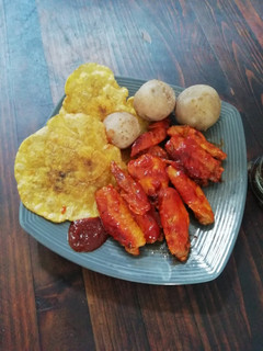 Una foto de Alitas bbq con pataconas y papá salada